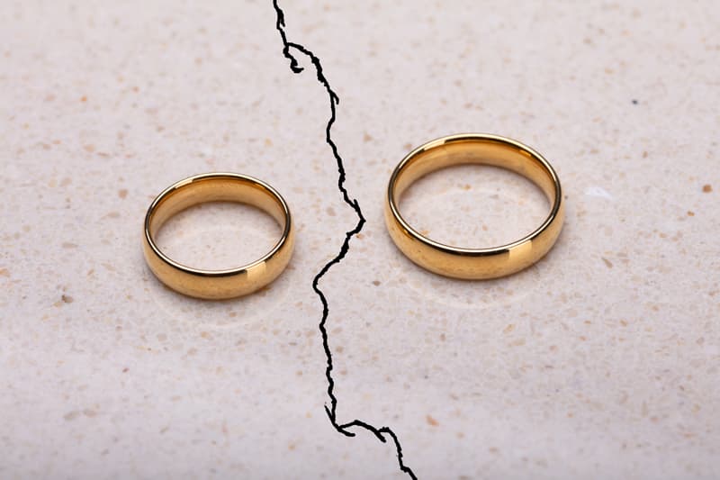 Two wedding rings divided, symbolising division of relationship property.