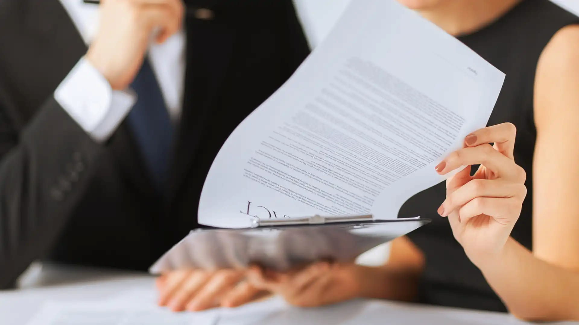 couple discussing papers with their lawyer in New Zealand